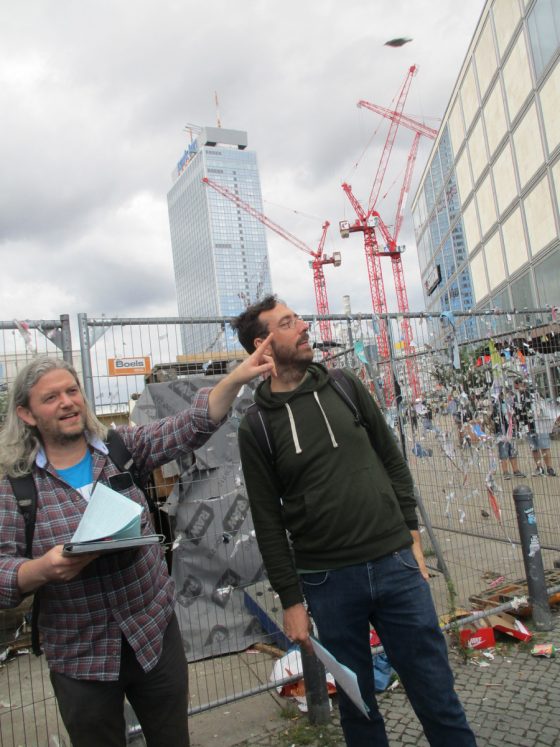 Fritz Grögel und Florian Hardwig vor Baukränen gegenüber dem Haus des Lehrers
